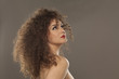 © vladimirfloyd - beautiful girl with long curly hair on a gray background