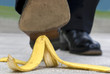 Man or businessman stepping slipping on banana skin peel danger accident photo