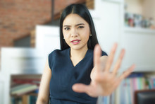 Asian Woman With Her Hand Signaling Stop (only Face Is In Focus)