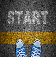 Pair Of Sneakers On Road With Yellow Print Of Word Start For The Concept Of Starting Point.