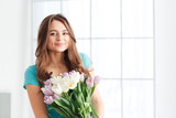 Fototapeta Tulipany - Happy beautiful young woman holding bouquet of tulips