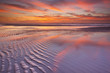Beautiful sunset and reflections on the beach at low tide