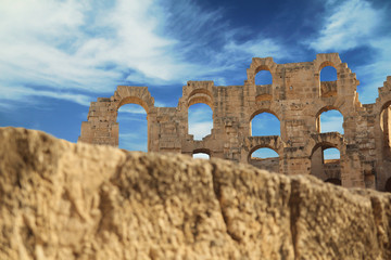 Ancient Amphitheater.

  Ancient ruined Amphitheater in front of blue cloudy sea with blured stone in foregorund