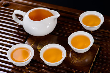 Chinese tea service cup of hot green tea, close-up, on black bac