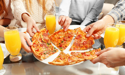 Wall Mural - Friends hands holding hot pizza, close up