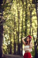 Wall Mural - beautiful young brunette woman in a Park at sunset with flower wreath