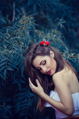 Wall Mural - beautiful young brunette woman in a Park at sunset with flower wreath