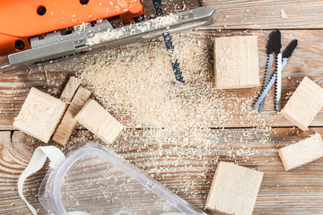 Wall Mural - Electric jigsaw with many wooden bricks full of sawdust.