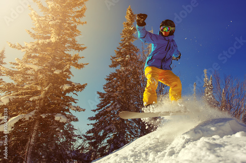 Photographie Snowboarder saut dans l'air avec un ciel bleu profond en arrière-plan