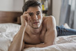 © theartofphoto - Shirtless sexy male model lying alone on his bed