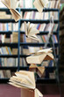 Flying books on library bookshelves background