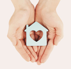 Poster - Female hands with model of house on light background