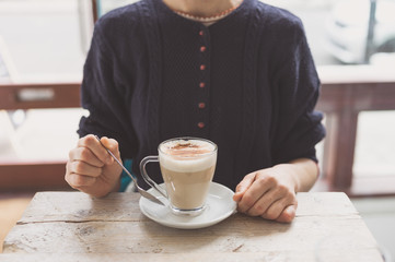 Young woman drinking latte in cafe