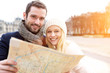 © Production Perig - Couple of young attractive tourists watching map