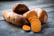 Raw Sweet Potatoes On Wooden Background 
