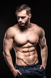 © goami - attractive bodybuilder sportsman shows perfect body muscles on black background