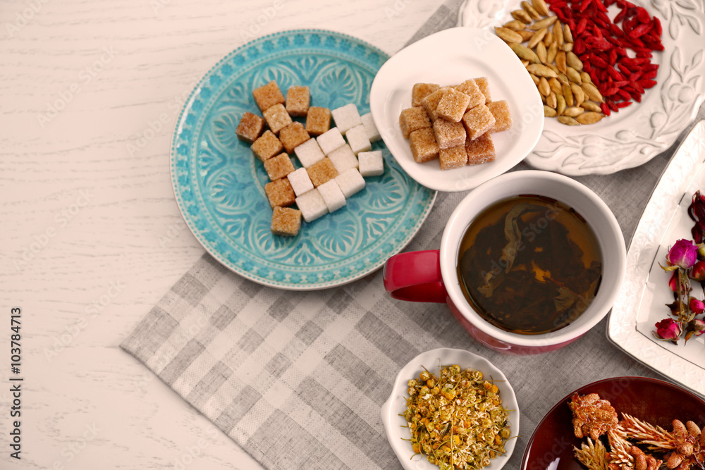 Cup of tea with aromatic dry tea on wooden background