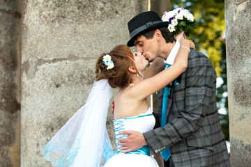 cute bride is hugging her groom, they are kissing on the backgro