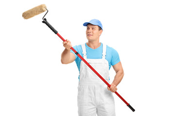 Poster - Young decorator painting with a paint roller