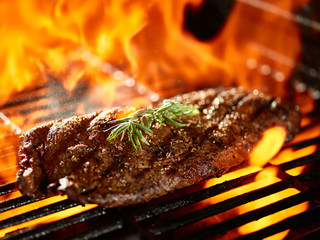 grilling a juicy flat iron steak over open flame