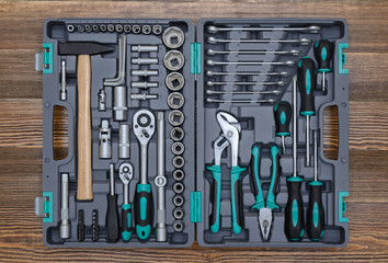 Wall Mural - Open toolbox with different instruments on wooden workbench