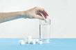 Glass of water against sugar, diabetes disease, sweet addiction, hand drop a sugar