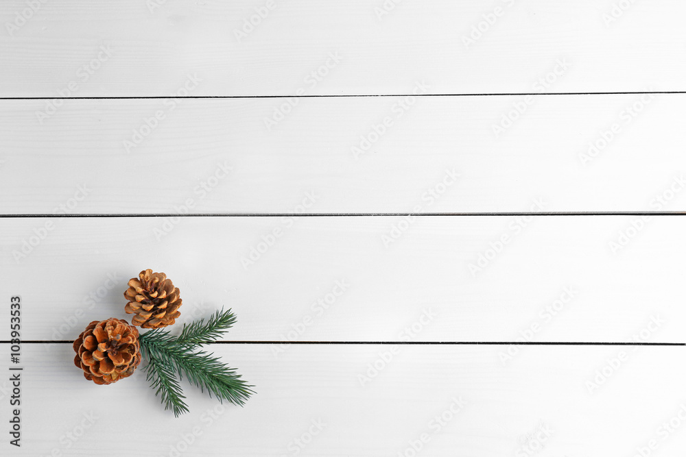Beautiful simple winter background with pine cones on wooden texture