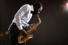 African American Jazz Musician Playing The Saxophone On Grey Background