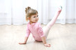 © Africa Studio - Little cute girl in pink leotard making new ballet movement at dance studio