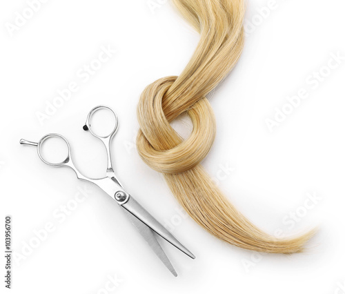 Hairdresser's scissors with strand of blonde hair, isolated on white Fototapete