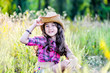 © sushytska - little girl sitting in a field wearing a cowboy hat