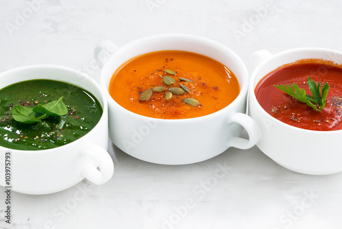 Fototapeta do kuchni assortment of colorful vegetable cream soup on a white table