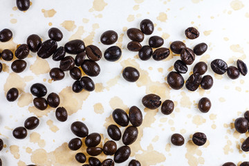 Wall Mural - Coffee beans and coffee stains on a white tablecloth..