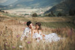 © olegparylyak - Beautiful wedding couple at picnic with fruit and cake on a background of mountains