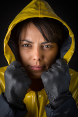 Canvas Print - Attractive young woman posing with a yellow raincoat