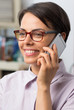 © punghi - Attractive young woman with glasses talks on her smartphone