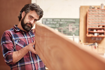 Sticker - Craftsman in his workshop looking down length of wooden plank