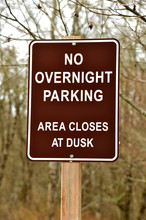 Metal Sign On Wooden Post Stating That No Overnight Parking Is Allowed