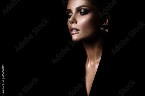 Poster the sexy strict woman with makeup and a fashionable hairstyle poses in studio o