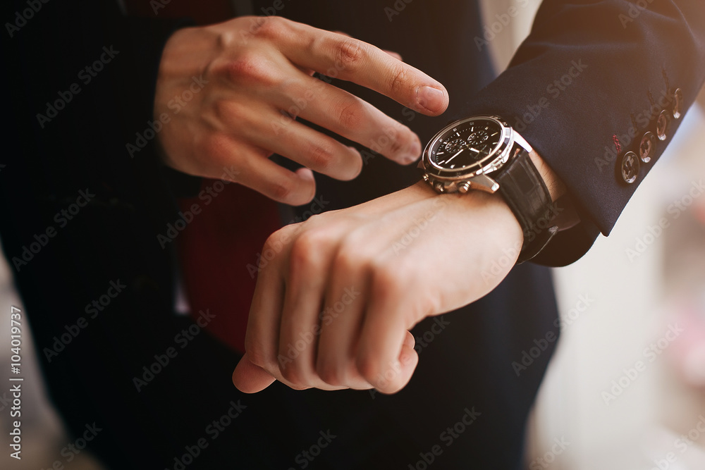 Closeup businessman looks at his watch - obrazy, fototapety, plakaty 