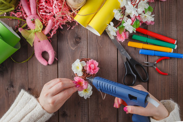 Wall Mural - Woman glue handmade flowers with melt gun