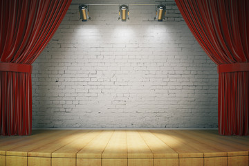 wooden stage with red curtains and a white brick wall with spotl