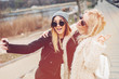 © sergiubirca - Outdoor lifestyle portrait of two best friends, smiling and having fun together, enjoy each other company posing and making selfie pictures to each other and share happiness