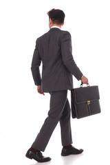 back view of a walking businessman with briefcase