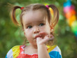 © evasilchenko - cute little girl wearing colorful dress sucks her thumb. Bad habit. in the park