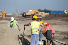Workers Beside Concrete Mixer