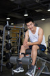 © zhu difeng - young man working out in modern gym