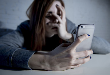 young sad vulnerable girl using mobile phone scared and desperat