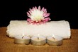 Flower, candles and towel on a burlap and black background