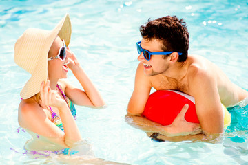 Canvas Print - Couple with sunglasses in swimming pool. Summer, sun, water.